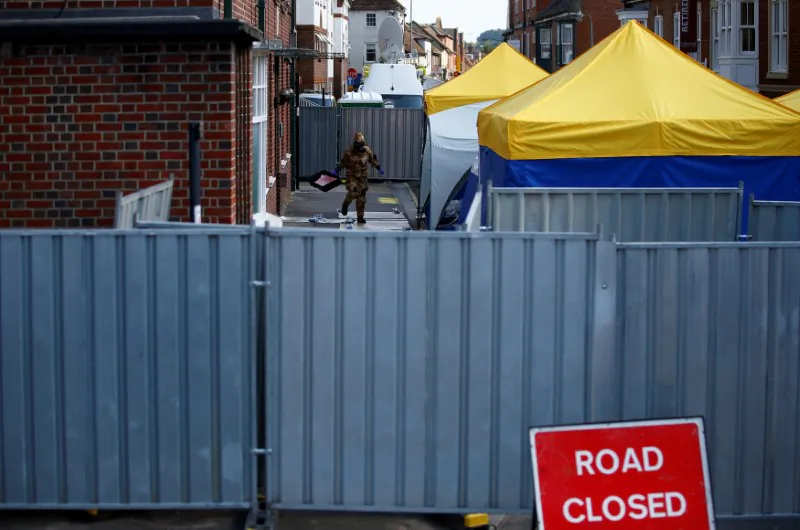 A forensic investigator, wearing a protective suit, emerges from the rear of John Baker House, after it was confirmed that two people had been poisoned with the nerve-agent Novichok, in Amesbury, Britain, July 6, 2018. (Reuters/Henry Nicholls/File Photo)