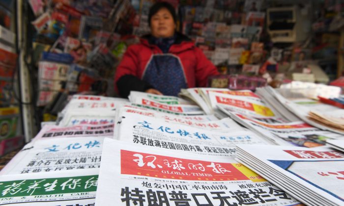 A newsstand vendor with state-run newspapers on sale, in Beijing on December 6, 2016. (Greg Baker/AFP/Getty Images)