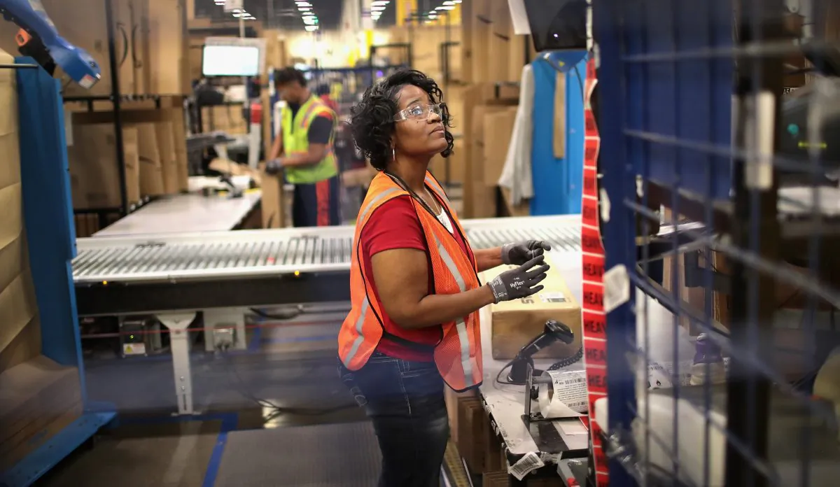 Workers pack and ship customer orders at an Amazon fulfillment center in Romeoville, Ill., on Aug. 1, 2017. (Scott Olson/Getty Images)