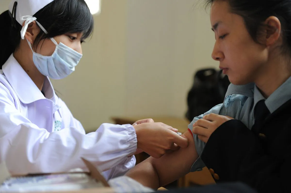 A Chinese nurse inoculates a woman with the swine flu vaccine at a hospital in Hefei City, in eastern China's Anhui Province on November 10, 2009. (STR/AFP/Getty Images)