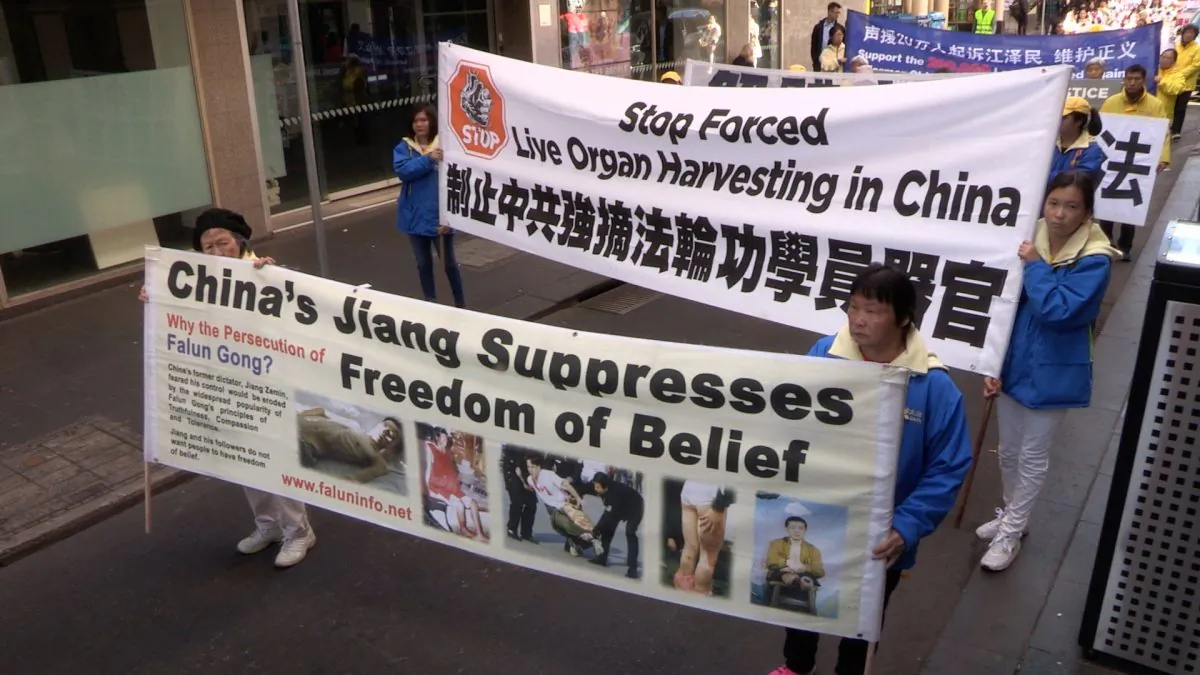 Falun Dafa practitioners holding banners raising awareness about forced organ harvesting and bringing Jiang Zemin to justice, in Melbourne, Australia on 14 July 2018. (Daniel Cameron/NTD)