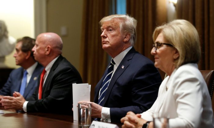 President Donald Trump sits between Rep. Kevin Brady (R-Texas) and Rep. Diane Black (R-Tenn.) after speaking about his summit with Russian President Vladimir Putin at the start of a meeting with members of the U.S. Congress at the White House on July 17, 2018. (REUTERS/Leah Millis)