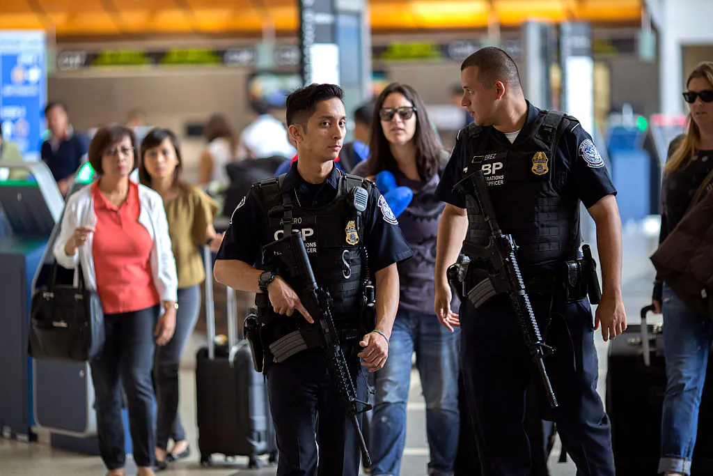 U.S. Customs and Border Protection officials watch over travelers at Los Angeles International Airport on July 2, 2016. (David McNew/Getty Images)