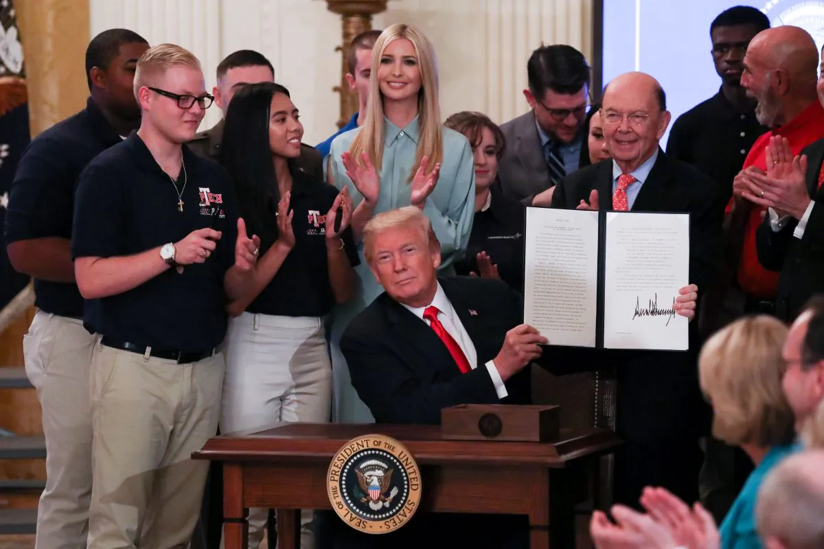 President Donald Trump signs an executive order during the "Pledge to America’s Workers" event in the East Room of the White House on July 19, 2018. (Samira Bouaou/The Epoch Times)