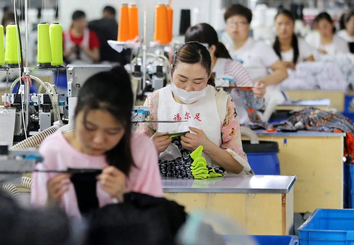 Employees work on socks that will be exported at a factory in Huaibei, Anhui province on June 22 (-/AFP/Getty Images)