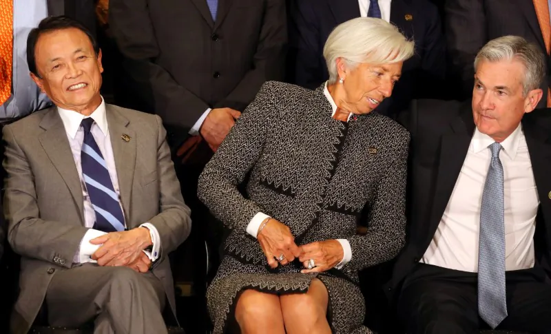 International Monetary Fund (IMF) Managing Director Christine Lagarde sits alongside Jerome Powell, Chairman of the U.S. Federal Reserve, and Japan's Minister of Finance Taro Aso as they pose for the official photo at the G20 Meeting of Finance Ministers in Buenos Aires, Argentina on July 21, 2018. (REUTERS/Marcos Brindicci)
