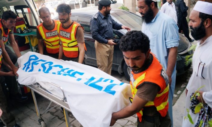 Rescue workers move the body of Ikramullah Gandapur, a candidate of the Pakistan Tehreek-e-Insaf (PTI), or Pakistan Justice Movement, who was killed in a suicide attack in the northwestern province of Khyber Pakhtunkhwa, outside hospital morgue in Dera Ismail Khan, Pakistan July 22, 2018. (Reuters/Stringer)