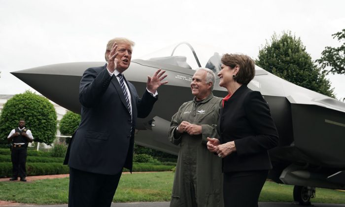 President Donald Trump (L) talks to Chairman, President and CEO of Lockheed Martin Marillyn Hewson (R) and Director and Chief Test Pilot Alan Norman (2nd L) in front of an F-35 fighter jet during the 2018 Made in America Product Showcase at the White House in Washington on July 23. (Alex Wong/Getty Images)