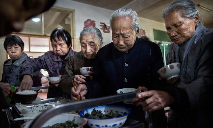 Elderly Chinese people serve themselves lunch at a nursing home in Sha County, Fujian Province, China, on March 17, 2016. (Kevin Frayer/Getty Images)