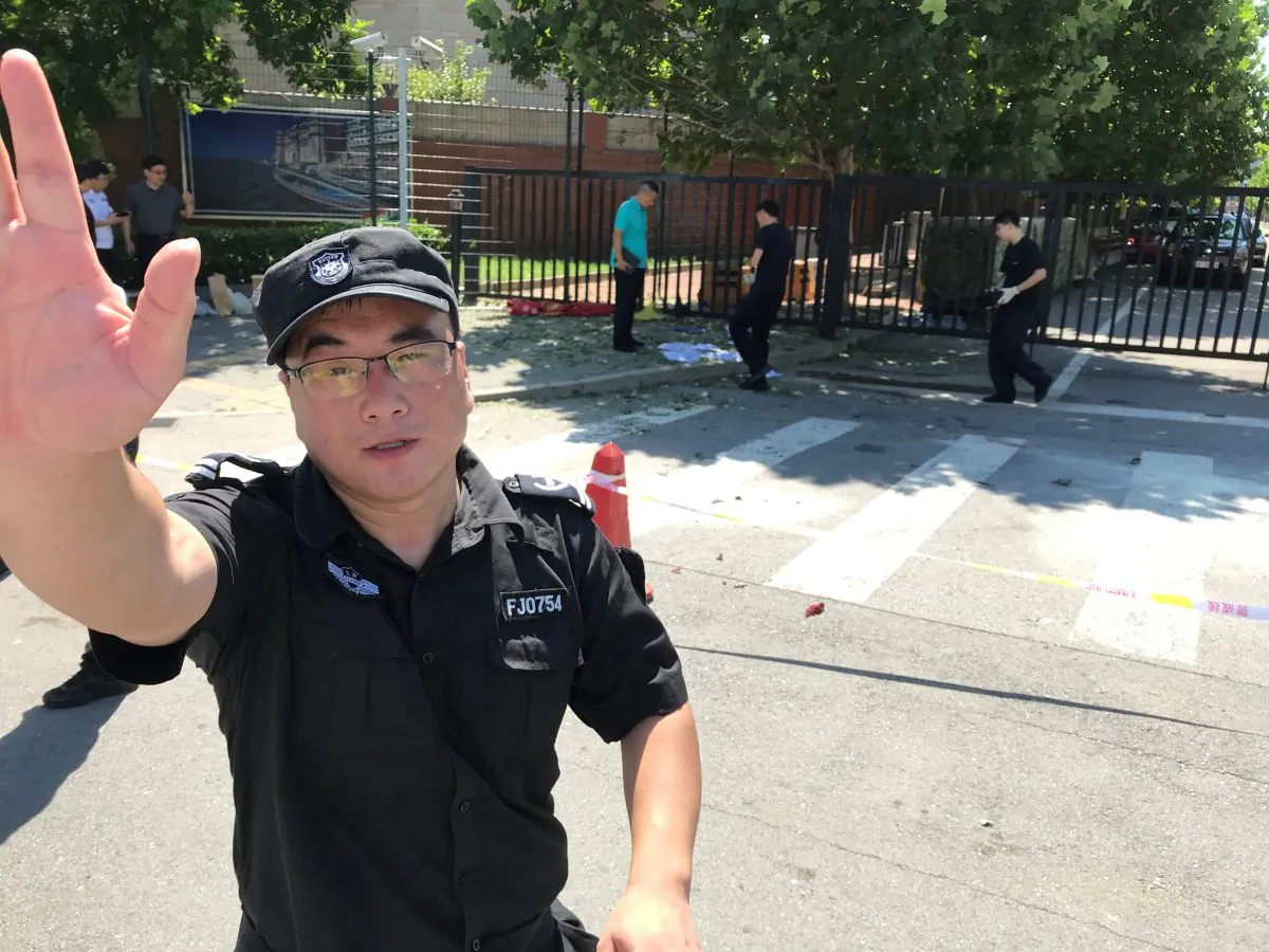 A security personnel gestures near the U.S. embassy in Beijing, China July 26, 2018. (Reuters/Thomas Peter)