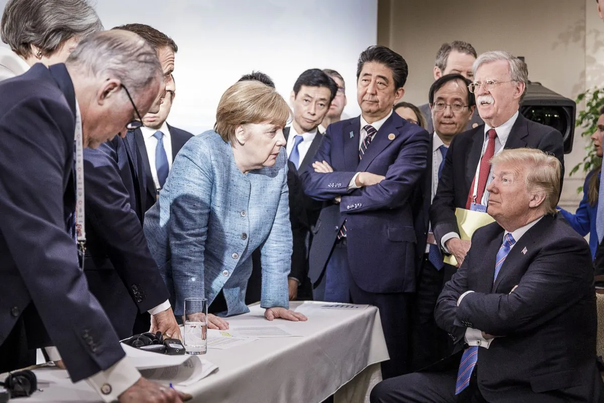 German Chancellor Angela Merkel speaks to President Donald Trump in front of other world leaders in Charlevoix, Canada, at the G-7 summit on June 9, 2018. The mainstream media and world leaders are blaming Trump for starting a trade war, where in reality all politicians are fighting to protect their special interest groups.    (Jesco Denzel /Bundesregierung via Getty Images)