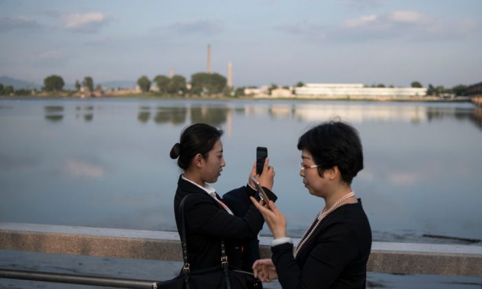 People take pictures by the Yalu River in the border city of Dandong, in China's northeast Liaoning Province, on May 30, 2018. (Fred Dufour/AFP/Getty Images)