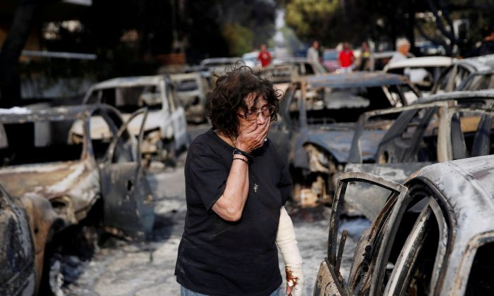 A woman reacts as she tries to find her dog, following a wildfire at the village of Mati, near Athens, Greece July 24, 2018. (REUTERS/Costas Baltas)