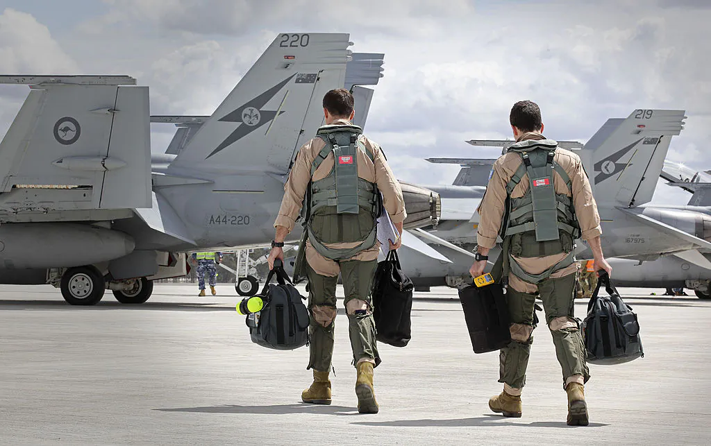 F/A-18F Super Hornet aircrew members head to their aircraft in preparation for departure to the Middle East from RAAF Base Amberley in Amberley, Australia, on Sept. 21, 2014. (CPL Ben Dempster/Royal Australian Air Force via Getty Images)