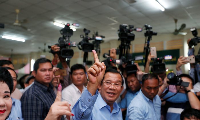 Cambodia's Prime Minister and President of the Cambodian People's Party (CPP) Hun Sen and his wife Bun Rany show their stained fingers at a polling station during a general election in Takhmao, Kandal province, Cambodia July 29, 2018. (Reuters/Samrang Pring)