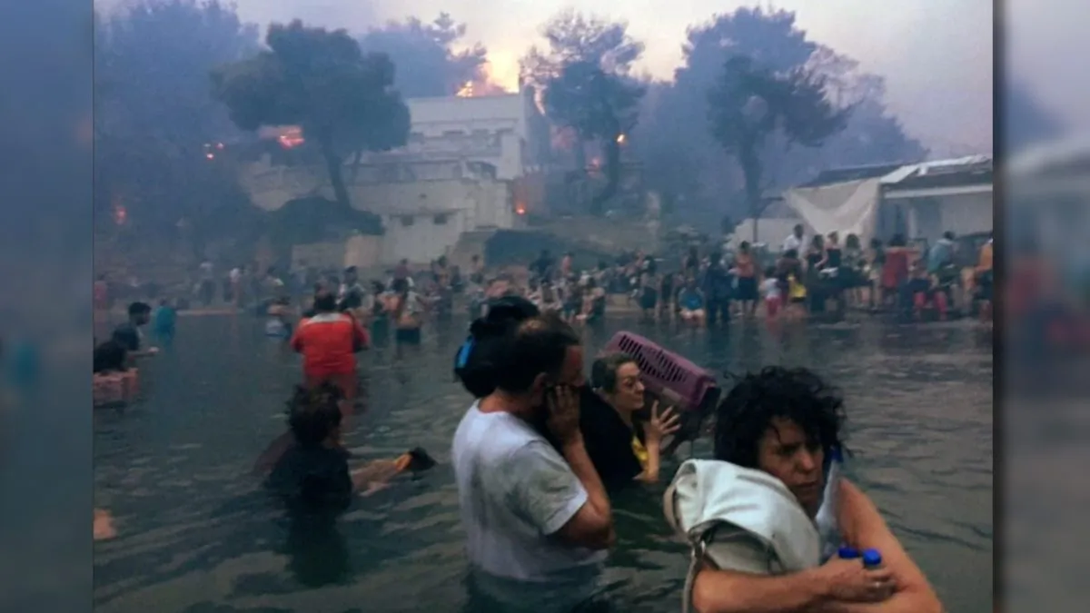 Dozens of people flee into the sea to escape wildfires sweeping through the Greek resort of Mati, on July 23, 2018. (Elia Kallia via Reuters)