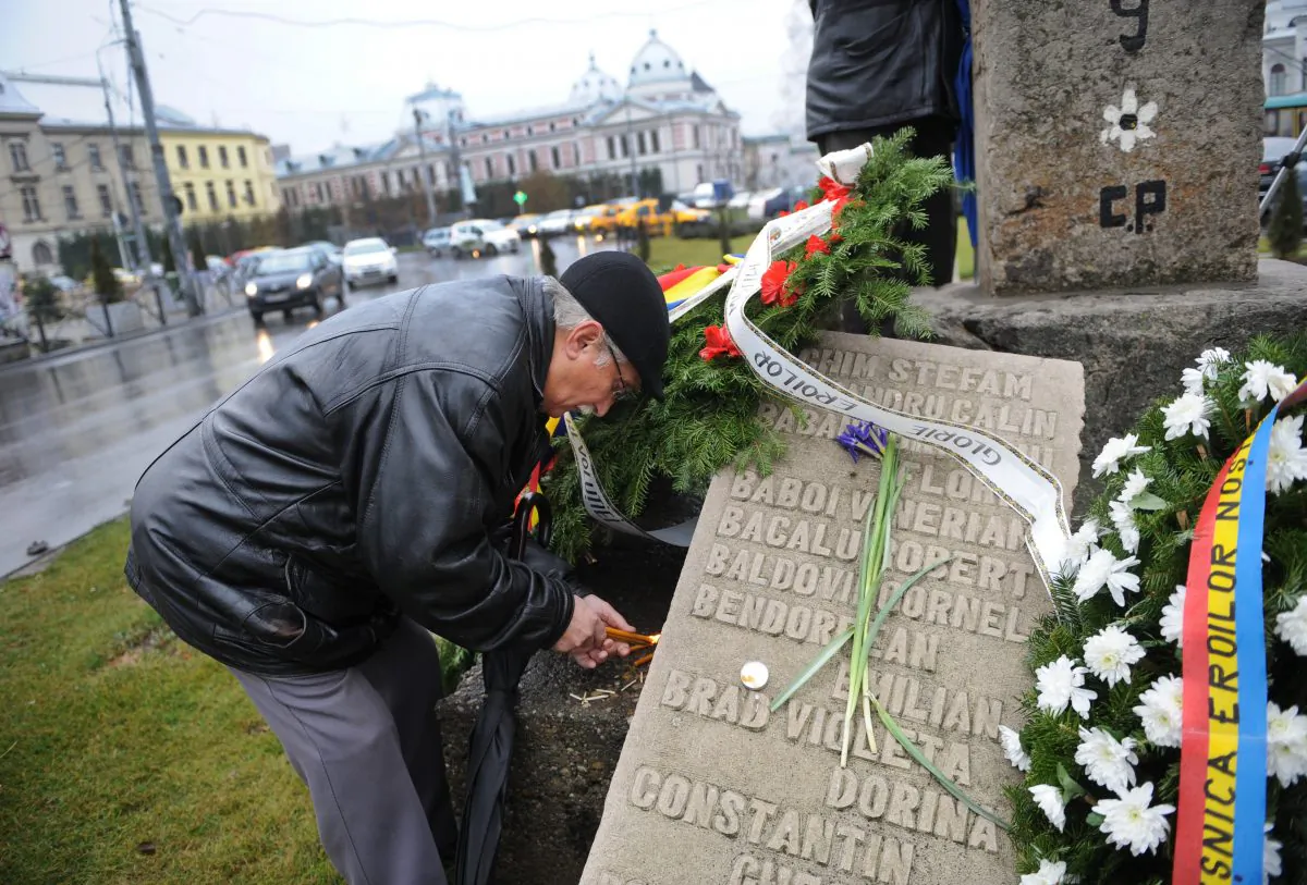 A man light candles during a commemoration ceremony in Bucharest on Dec. 21, 2011, next to a stone bearing names of people killed by communist regime forces in 1989. (Daniel Mihailescu/AFP/Getty Images)