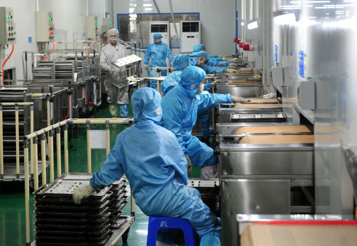 Employees work in a factory producing touchscreen glass, in Liuyang City, Hunan Province, on March 12, 2015.(STR/AFP/Getty Images)
