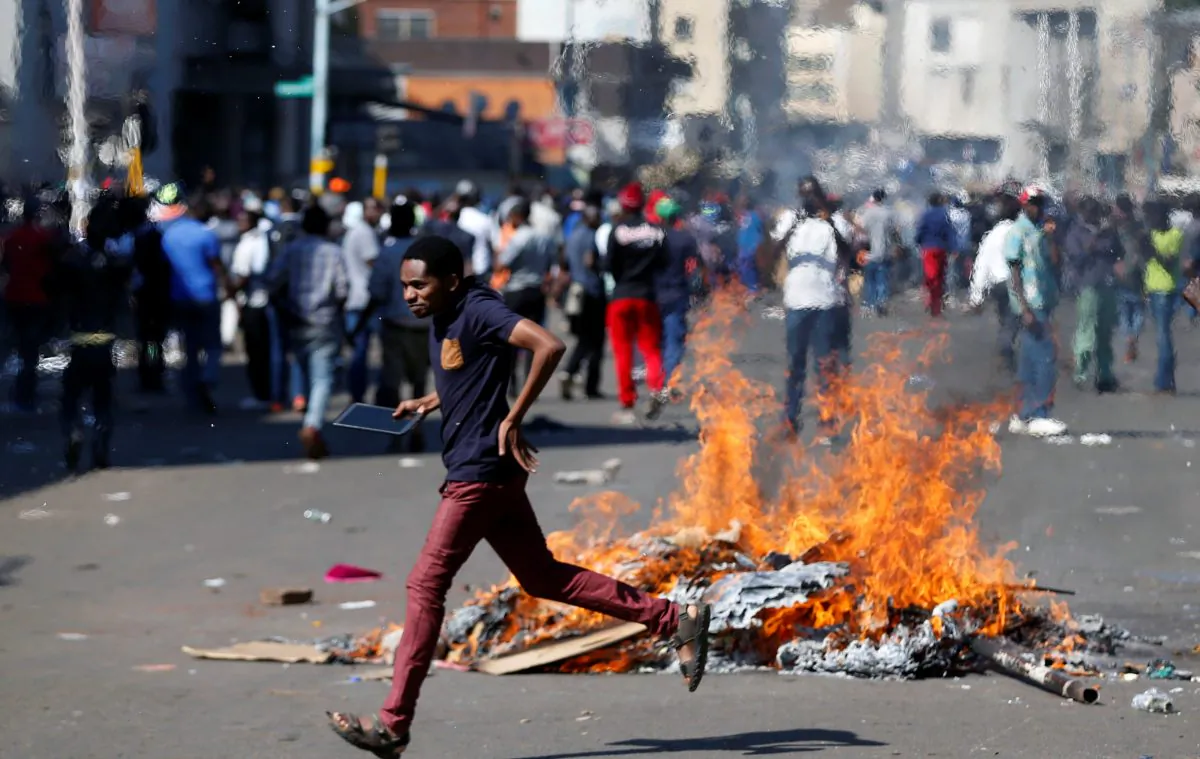 A man runs as supporters of the opposition Movement for Democratic Change party (MDC) of Nelson Chamisa burn barricades in Harare, Zimbabwe, August 1, 2018. (Reuters/Siphiwe Sibeko)