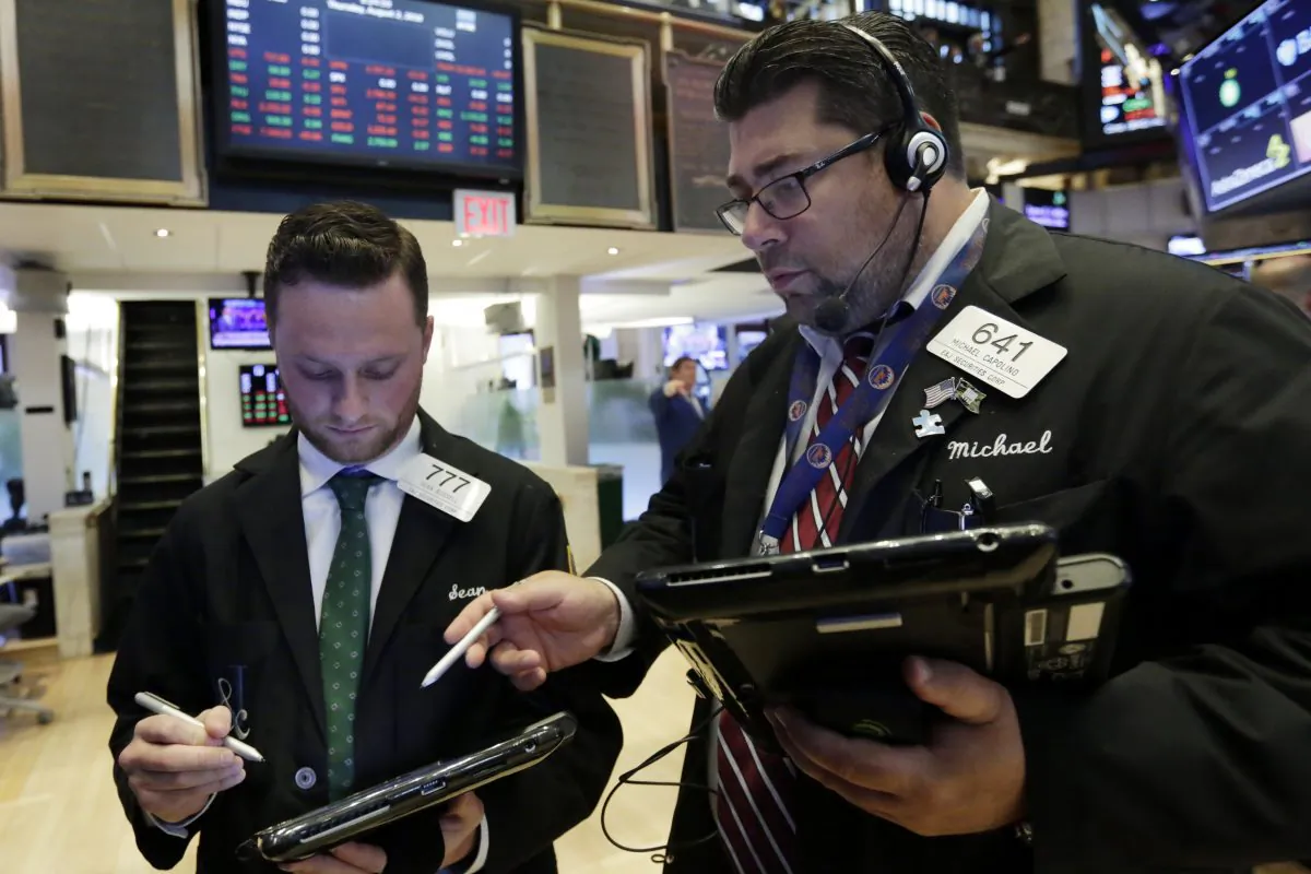 Traders Sean Russell (L) and Michael Capolino confer as they work on the floor of the New York Stock Exchange on Aug. 2, 2018. (AP Photo/Richard Drew)