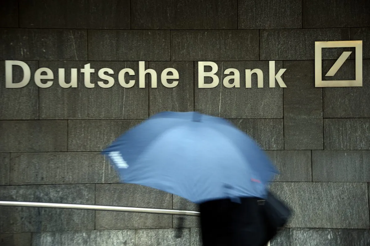 A woman with a umbrella passes a logo of Deutsche Bank on January 29, 2013 in Frankfurt am Main, Germany. (Thomas Lohnes/Getty Images)