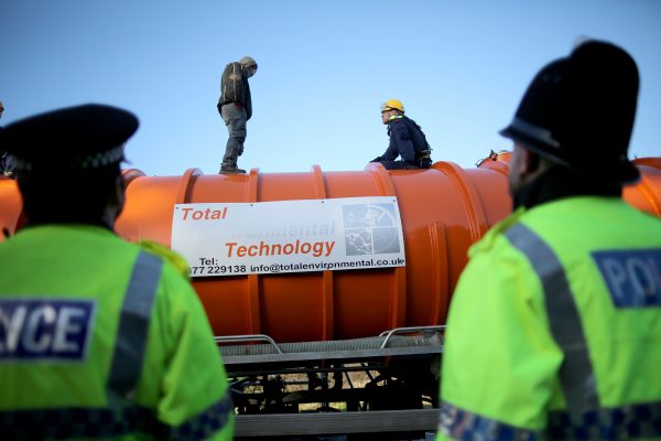 A policeman edges his way towards an anti-fracking protester standing on the top of a truck carrying chemicals to the Barton Moss gas fracking facility on Jan. 13, 2014 in Barton, England.