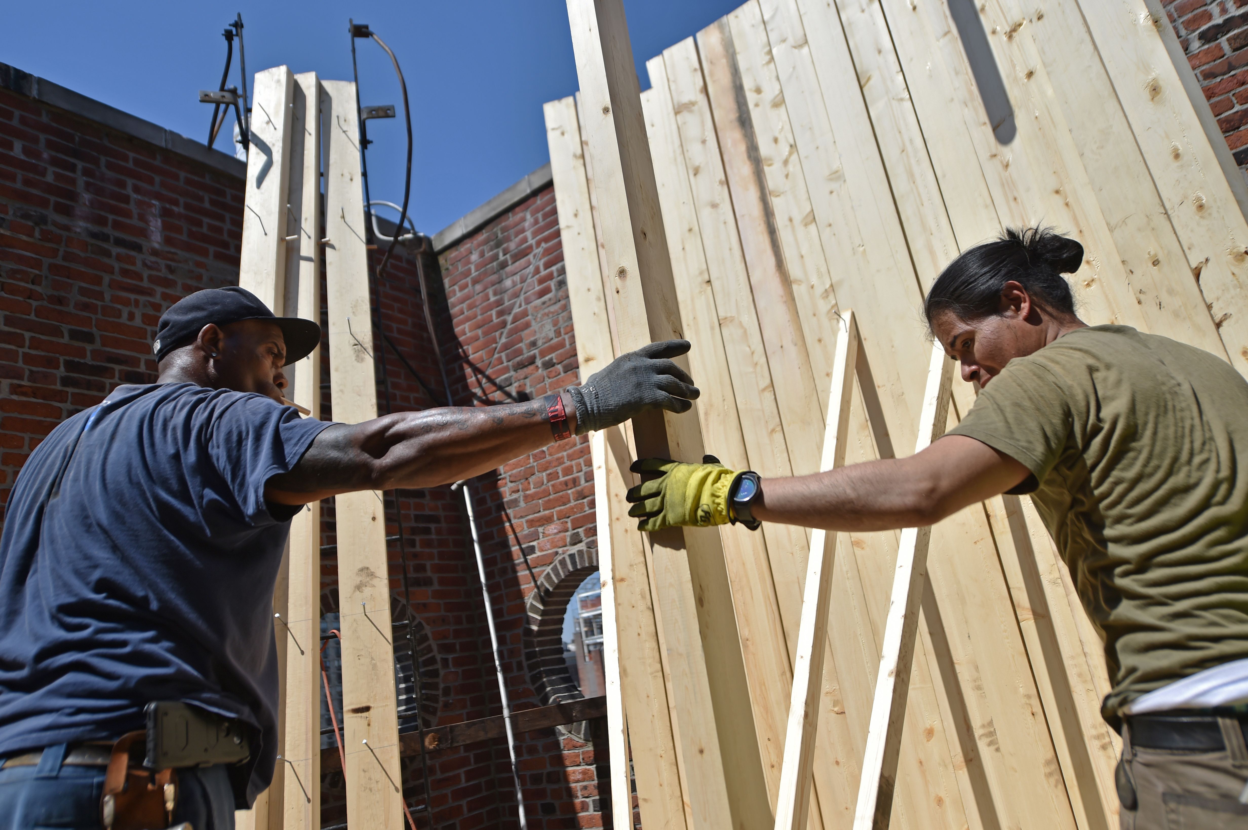 Workers install a water tank on a building on Lexington Ave in New York City on May 9, 2018. (Hector Retamal/AFP/Getty Images)