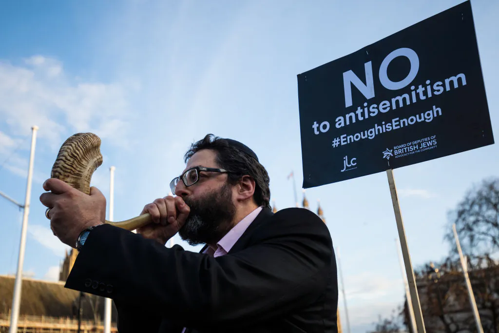 A protester blows through a shofar during a demonstration in Parliament Square against anti-Semitism in Jeremy Corbyn's Labour Party, in London, on March 26, 2018. (Jack Taylor/Getty Images)