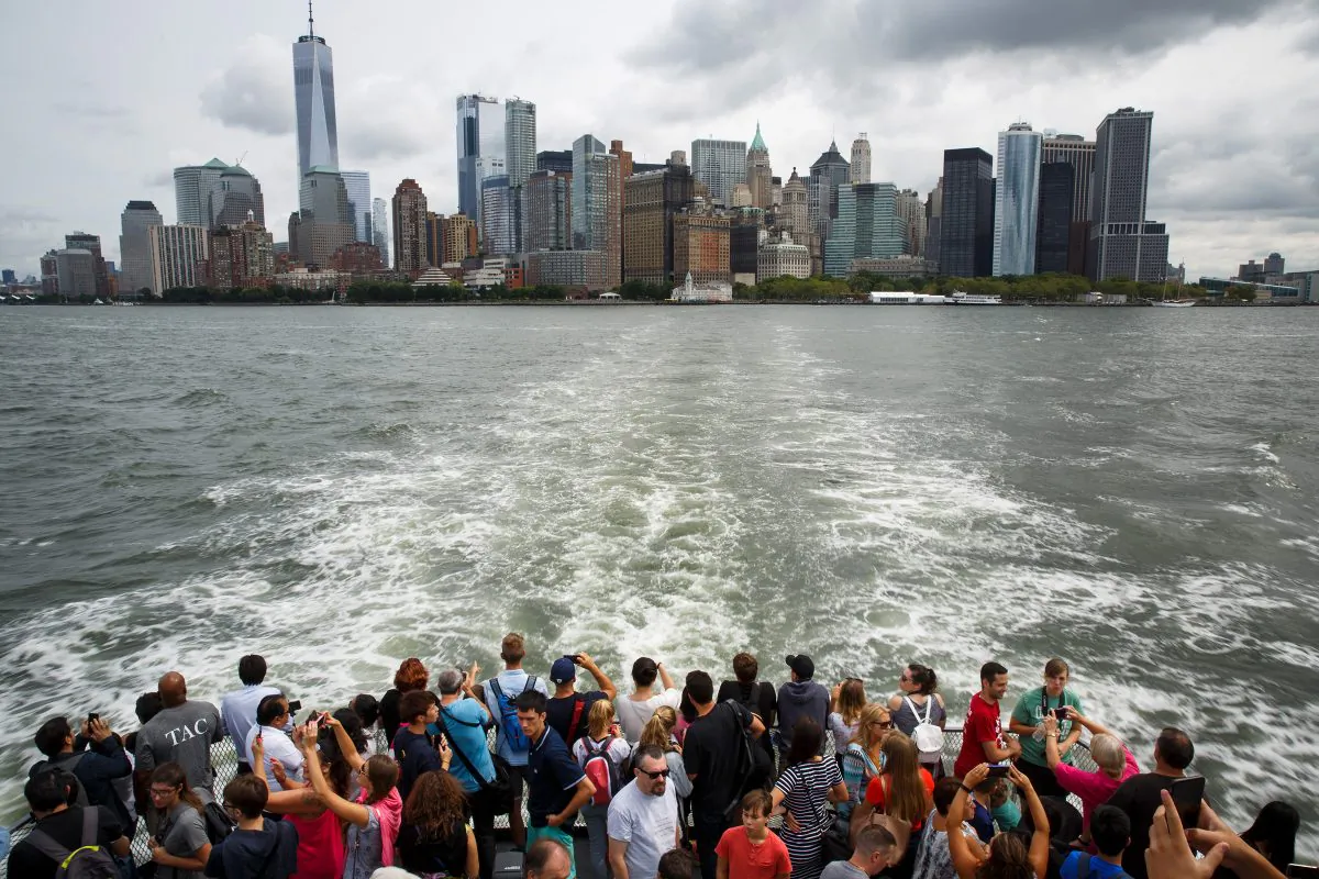 With Lower Manhattan in the background, visitors and tourists ride a ferry toward Liberty Island and the Statue of Liberty in New York City, August 8, 2017. (Drew Angerer/Getty Images)