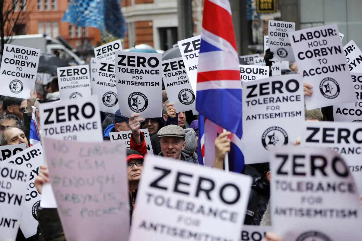 People hold up placards and Union flags as they gather for a demonstration organised by the Campaign Against Anti-Semitism outside the head office of the British opposition Labour Party in central London on April 8, 2018. (TOLGA AKMEN/AFP/Getty Images)