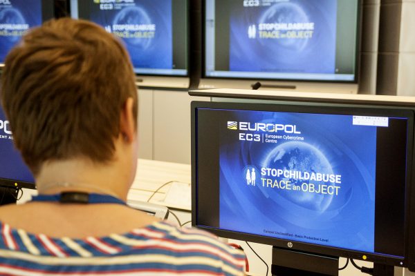 A Europol police agent looks at the onscreen logo of a new website launched by Europol. Europe's police agency launched the new website, which shows everyday objects found in the background of child sex abuse images, in the hope that it will lead police around the world to victims and help arrest perpetrators. (JAN HENNOP/AFP/Getty Images)