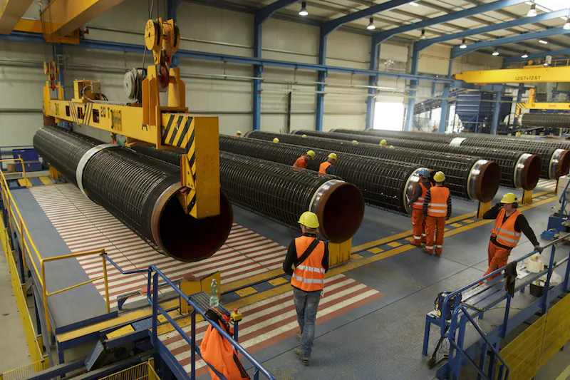 A crane transports a pipe in a production hall at the Nord Stream 2 facility at Mukran on Ruegen Island in Sassnitz, Germany, on Oct. 19, 2017. (Carsten Koall/Getty Images)