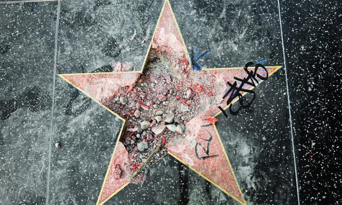 This photo shows Donald Trump's star on the Hollywood Walk of Fame that was vandalized Wednesday, July 25, 2018, in Los Angeles. Los Angeles police Officer Ray Brown said the vandalism was reported early Wednesday and someone was subsequently taken into custody. Authorities said a pickax was used in the vandalism. (AP Photo/Reed Saxon)
