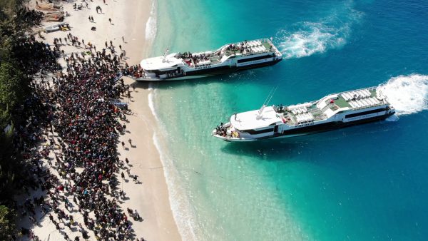 Boats arrive at shore to evacuate people on the island of Gili Trawangan, Lombok, Indonesia, Aug. 6, 2018, in this still image taken from a drone video obtained from social media.