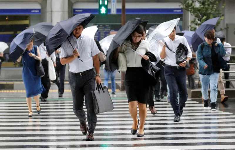 Passersby using umbrellas struggle against a heavy rain and wind as Typhoon Shanshan approaches Japan's mainland in Tokyo, Japan Aug. 8, 2018. (Reuters/Toru Hanai)