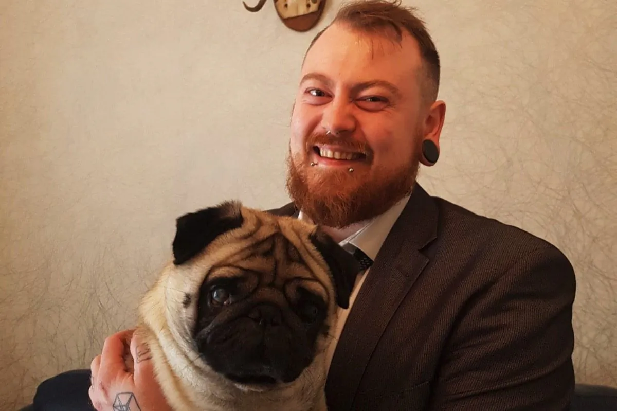 Mark Meechan, shown holding his girlfriend's pet pug, has lost his appeal of a hate speech conviction in the UK. He says the ruling unfairly ignores the comedic context of a video he posted of the dog doing Nazi salutes, and says he is prepared to go jail in defiance of the court and in defence of his right to free speech. (GoFundMe/Mark Meechan)