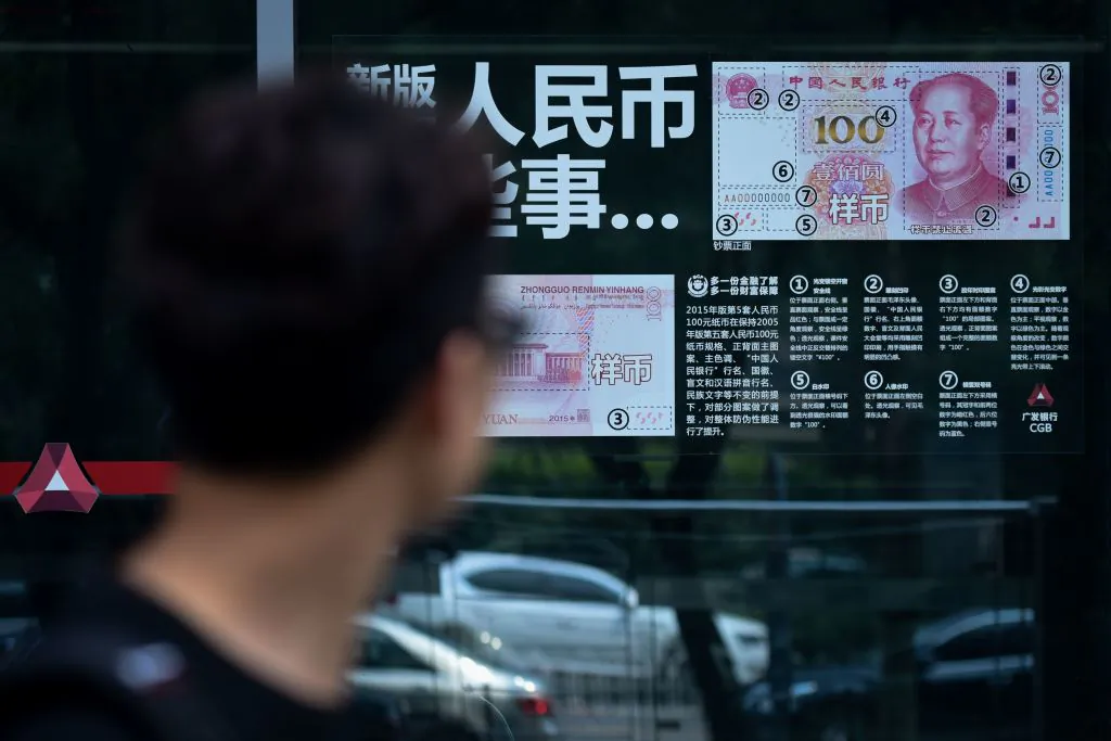 A man looks at currency information posted on the window of a bank in Beijing on July 20, 2018. (Wang Zhao/AFP/Getty Images)