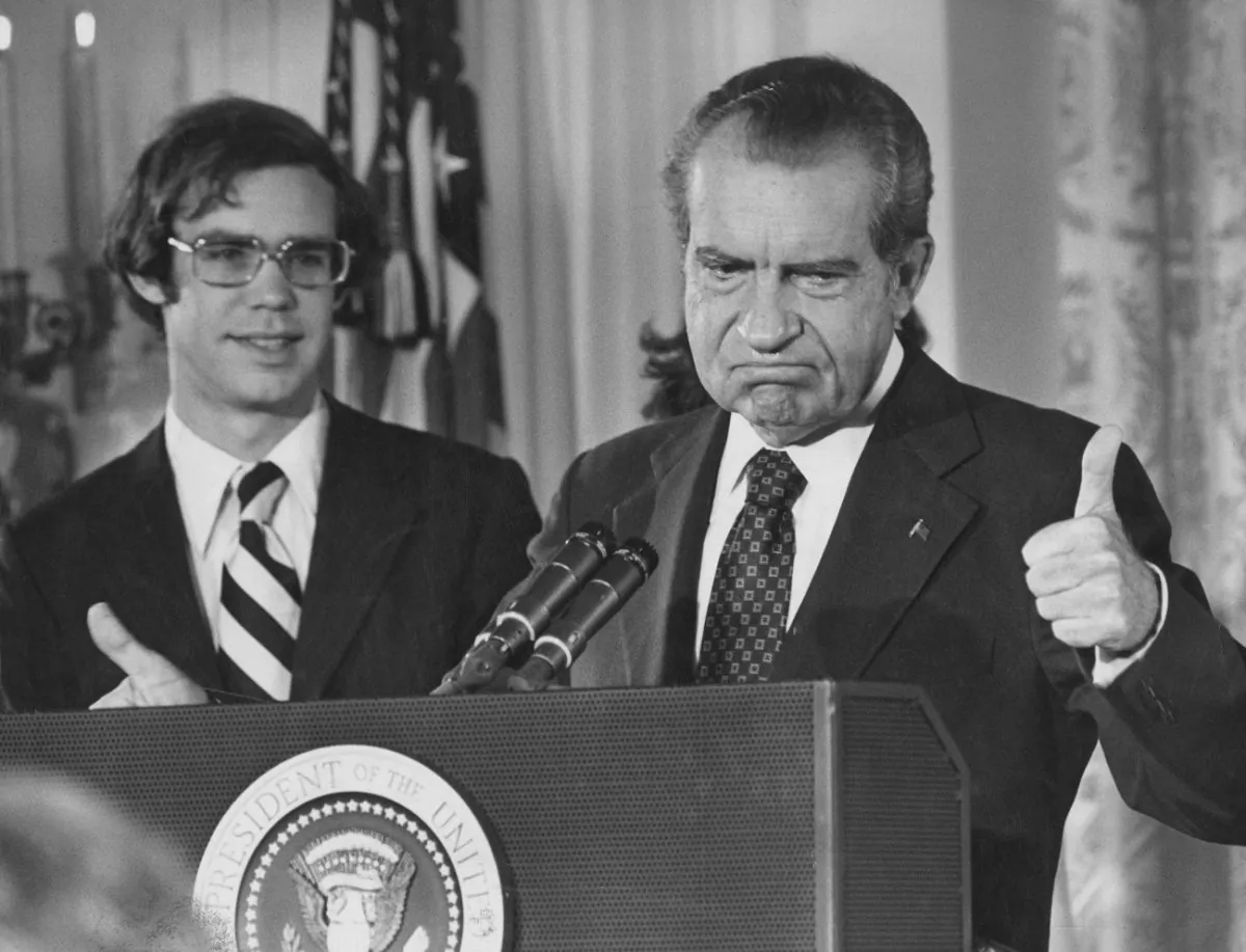 Former President Richard Nixon (1913 - 1994) gives the thumbs up as he addresses the White House staff upon his resignation as 37th President of the United States, Washington, Aug. 9, 1974. His son-in-law David Eisenhower is with him on the left. The Washington Post demonstrated the power of the media by doing reporting that helped force Nixon’s resignation. (Keystone/Hulton Archive/Getty Images)