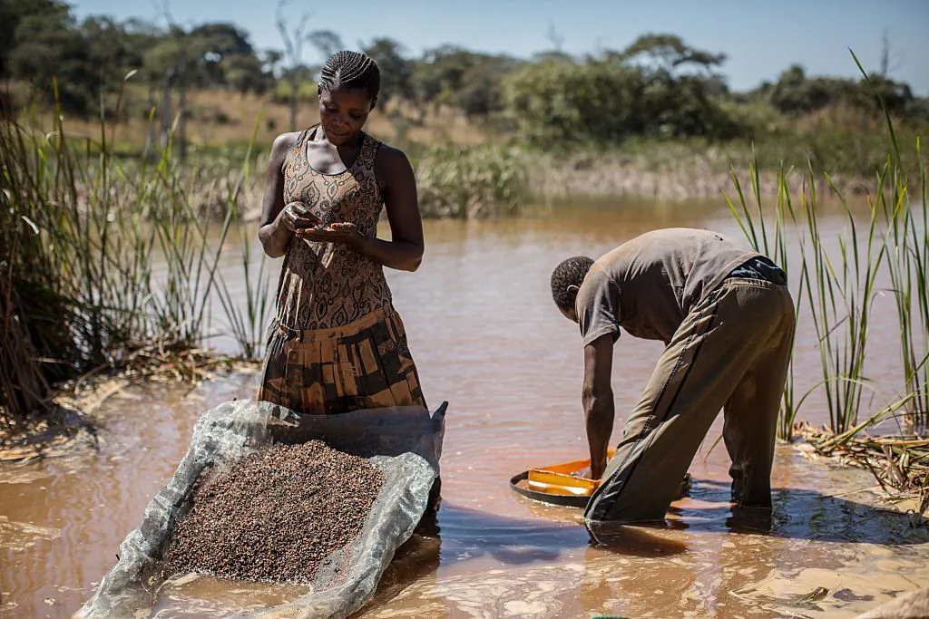A woman and a man seperate cobalt from mud and rocks near a mine between Lubumbashi and Kolwezi, Democratic Republic of the Congo, on May 31, 2015. (Federico Scoppa/AFP/Getty Images)