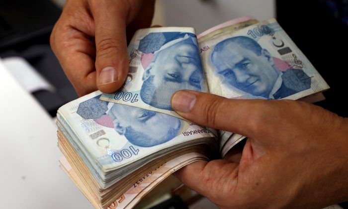 2018 年 8 月 2 日，一名货币兑换商在土耳其伊斯坦布尔的货币兑换处清点土耳其里拉纸币。（路透社 / Murad Sezer / 档案照片）