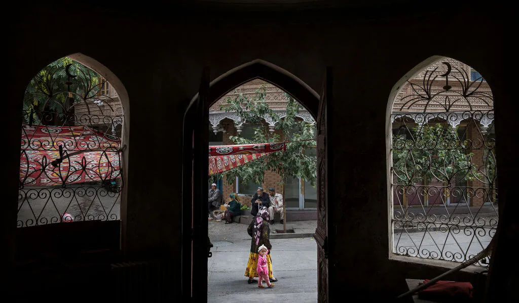 An ethnic Uyghur woman walks by a closed Islamic school on July 1, 2017 in the old town of Kashgar, in the far western Xinjiang province, China. (Kevin Frayer/Getty Images)