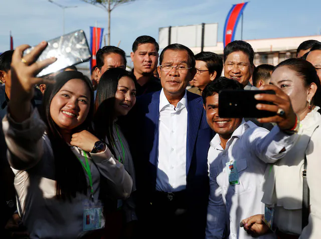 Supporters take pictures with Cambodia's Prime Minister Hun Sen (C) as he attends an inauguration of a new boat terminal in Phnom Penh, Cambodia, on Aug. 1, 2018. (Samrang Pring/Reuters)