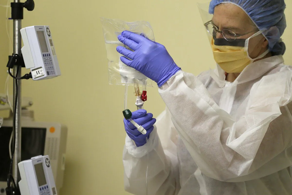 In this Monday, Nov. 13, 2017 file photo, a nurse practitioner prepares to start the first human gene editing treatment for Hunter syndrome, an inherited metabolic disease, at a hospital in Oakland, Calif. On Wednesday, Aug. 15, 2018, federal officials said that gene therapy is becoming an established form of medical care and carries no special risks that warrant special regulation, as they revised rules for vetting such experiments and products. (AP/Eric Risberg)