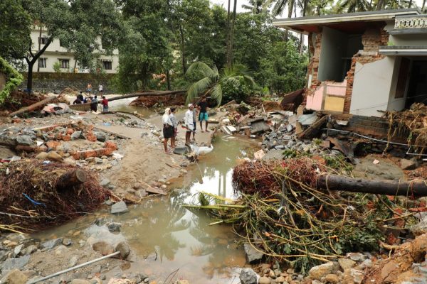 Indian residents look at houses destroyed by flood waters at Kannappankundu in Kozhikode, in the Indian state of Kerala on Aug. 10, 2018.