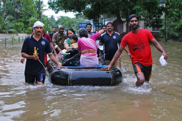 Indian volunteers and rescue personnel evacuate local residents in a boat in a residential area at Kozhikode, in the Indian state of Kerala, on Aug. 16, 2018.