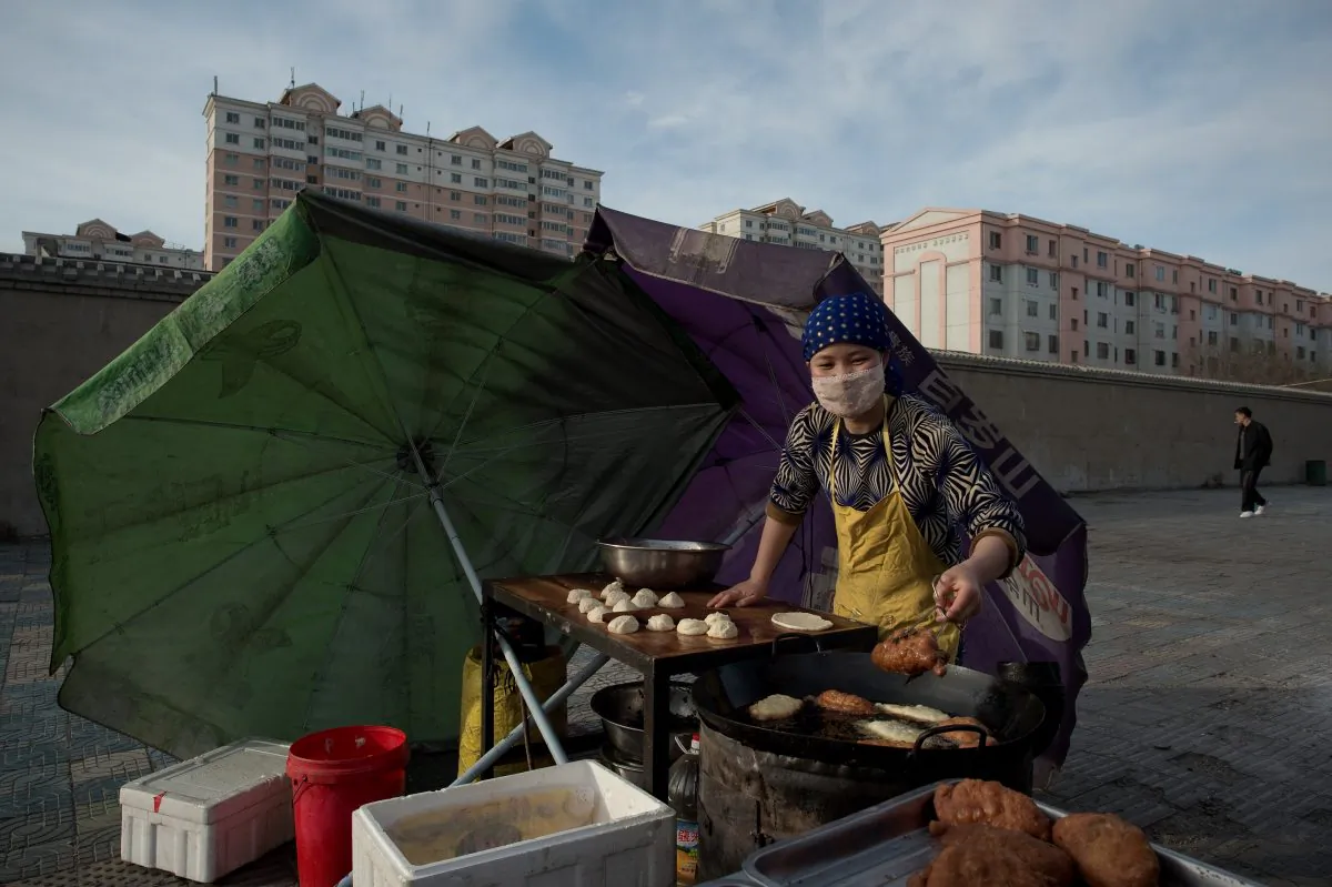 A street vendor cooks food as the sun rises over the city of Jiayuguan, Gansu Province, on April 22, 2016. (Nicolas Asfouri/AFP/Getty Images)
