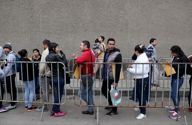 Venezuelan migrants wait at the Interpol headquarters in Lima to get paperwork needed for a temporary residency permit