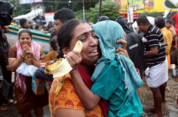 A woman cries as she holds her son after they were evacuated from a flooded area in Aluva in the southern state of Kerala, India on August 18, 2018. (Sivaram V/REUTERS)