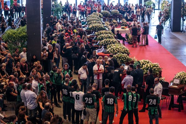 Relatives mourn by coffins of victims