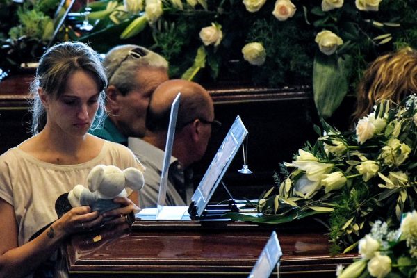 A relative of a victim of the bridge collapse holds a teddy bear